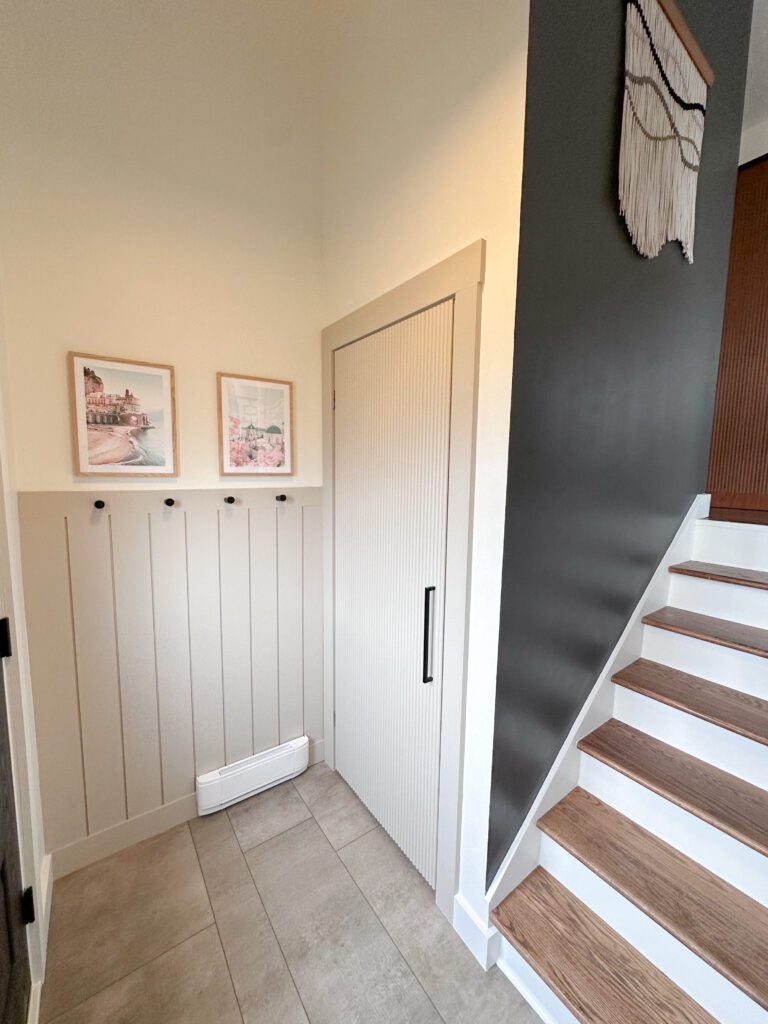 shiplap half wall with hooks and accent door for closet