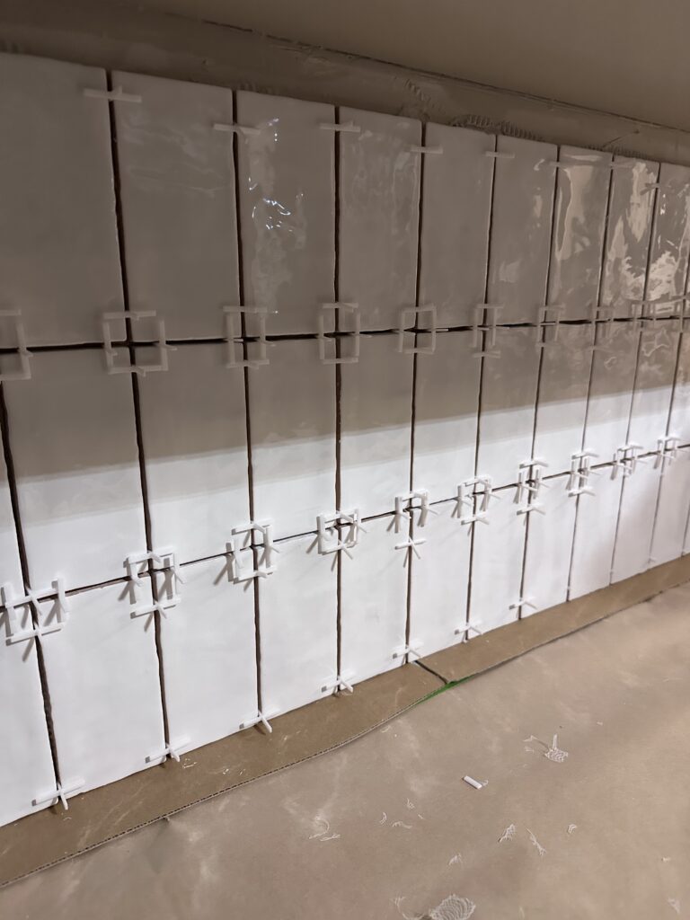 how to apply the adhesive to the tile with the spacers