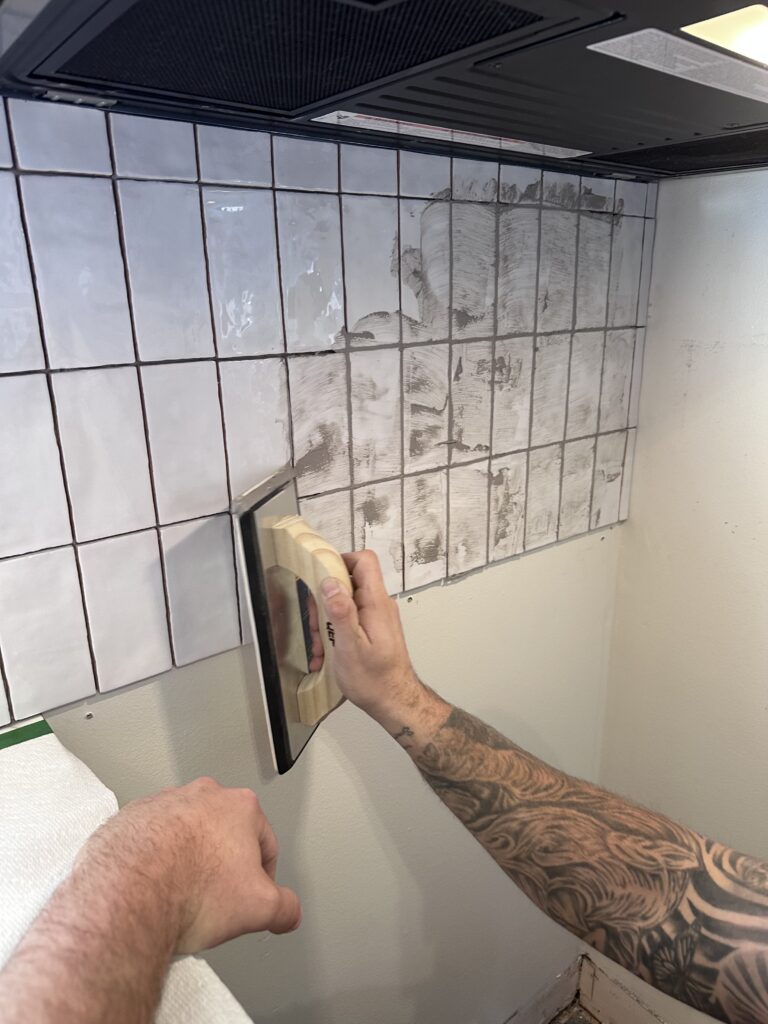 grouting the tile with warm grey