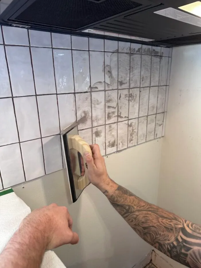 grouting the tile with warm grey